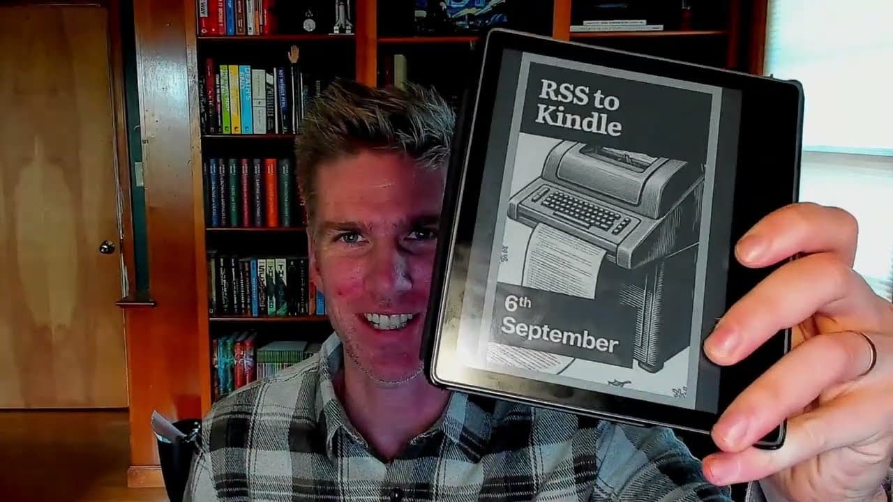 Marty holding a Kindle showing the RSS to Kindle digest cover for the 6th of September